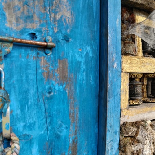 La porta di un vecchio tempietto con le ruote di preghiera